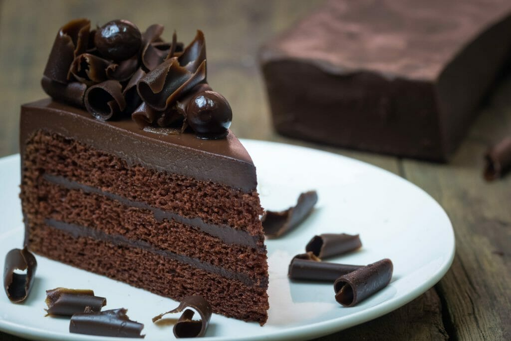 chocolate cake topping with chocolate curl wood background scaled 1